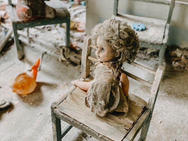 Foto kinderspeelgoed bedekt met stof en puin in de ruïnes van een verlaten huis. verlaten en verwoeste huizen na het ongeval in de kerncentrale van tsjernobyl.