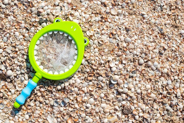 Kinderspeelgoed, een net om op schelpen op het strand te vissen. Bovenaanzicht, plat gelegd.