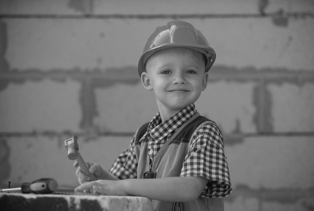 Kinderspel met benodigdheden, gereedschap, zaaghamer, schroevendraaier, helm, bouwer, timmerman, kinderen spelen in de p