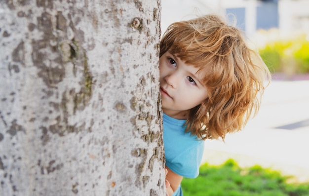 Kinderspelletjes verstoppertje kiekeboe jongetje verstopt bij boom