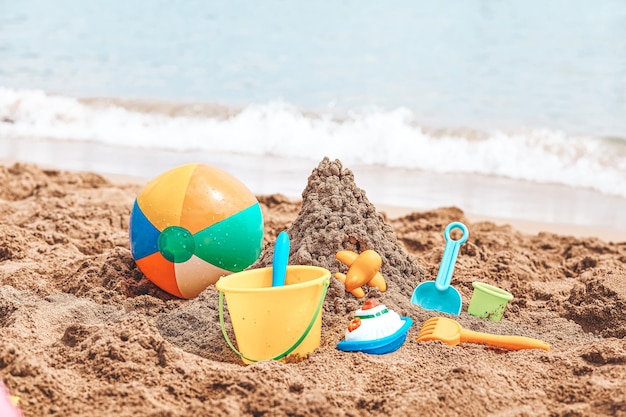 Kinderstrandspeelgoedemmers schop en schop op zand op een zonnige dag