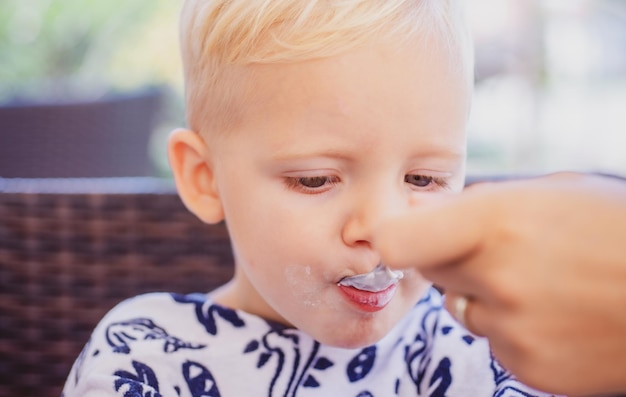 Kindervoeding Babyjongen voeden met lepel Vaderschap moeder of zus met kind