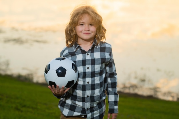 Kindervoetballer of voetballer in actie op een voetbalstadion die een voetbal schopt voor het doelconcept
