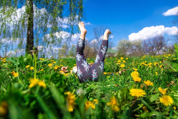 Kindervoeten op het gras in de lente paardebloemen tuin Selectieve aandacht