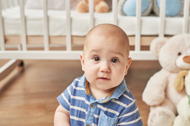 kindjongen speelt houten speelgoed in een kinderkamer in heldere kleuren, kinderkamer in Scandinavische stijl