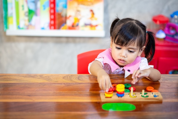 Kindmeisje die houten speelgoed spelen