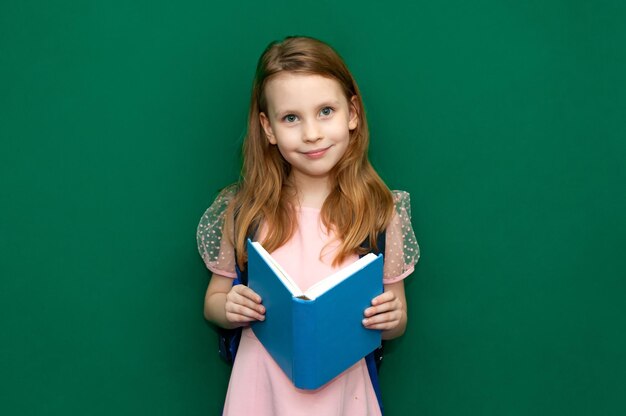 Kindmeisje met een schooltas en boeken in handen