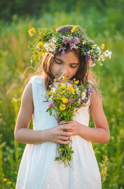 Kindmeisje met wilde bloemen in de zomer