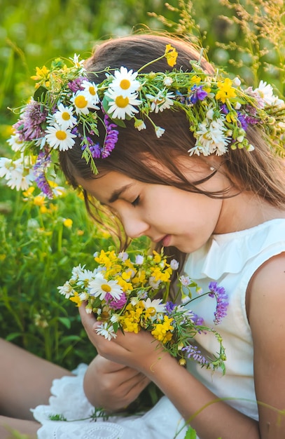 Kindmeisje met wilde bloemen in de zomer