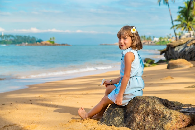 Kindmeisje op het strand in Sri Lanka.