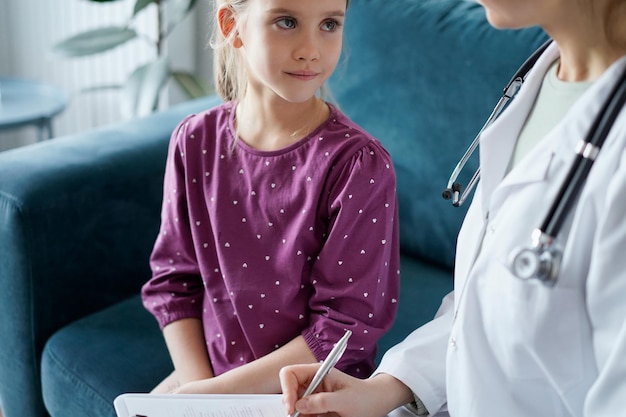 Kindpatiënt bij gebruikelijke medische keuring. Dokter en kindpatiënt thuis. Geneeskunde, gezondheidszorgconcepten