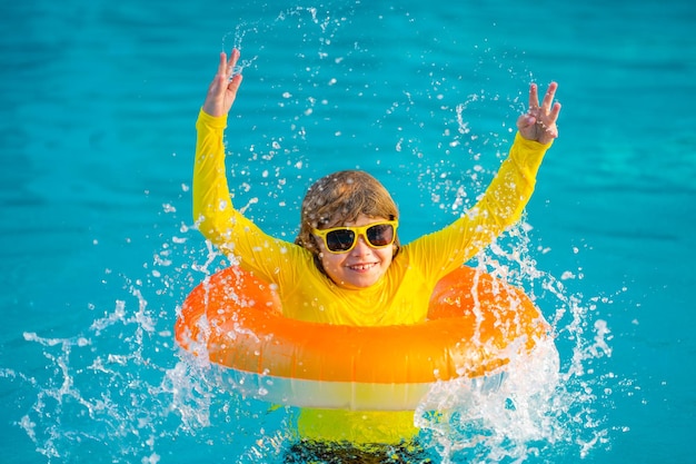 Kindspel in pool op opblaasbare ringjong geitje met opblaasbare ring in het waterspeelgoed chi van het zwembadkind