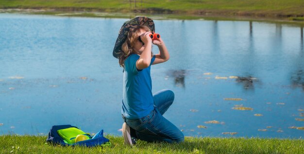 Kindtoeristen met rugzakken Avontuurlijke reizen en toerisme concept Kind wandelen met rugzakken op de natuur Kleine ontdekkingsreiziger op reis