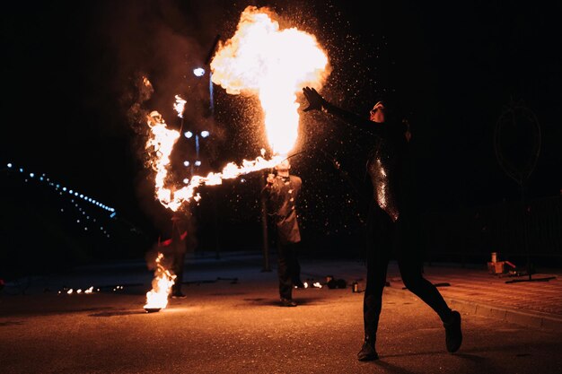 KINESHMA RUSSIA OCTOBER 09 2021 Girl with a burning sparkling torch presents a fire show and pyrotechnic performance