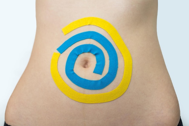 Kinesio tape on the abdomen of a young woman