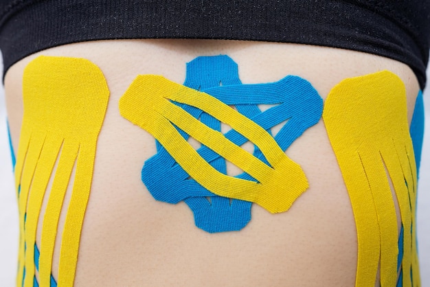 Kinesio tape on the abdomen of a young woman