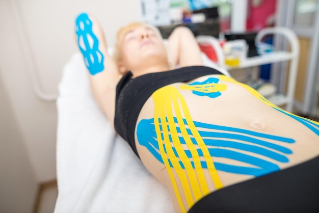 Kinesio tape on the abdomen of a young woman