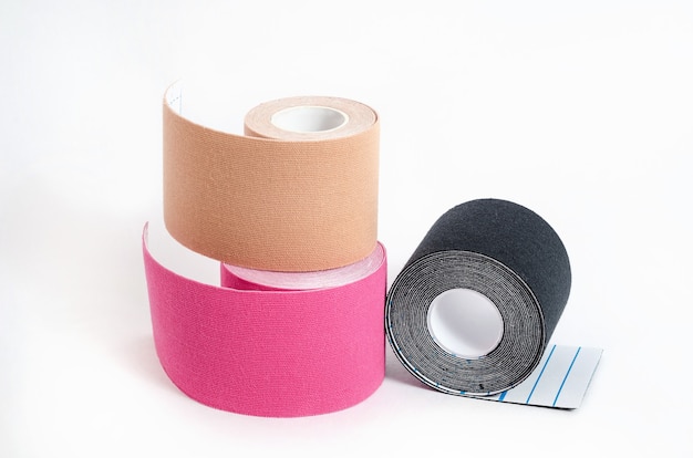 Kinesiological multi-colored tapes for fixing muscles during sports and after injuries on a white surface. Kinesiological taping of athletes.