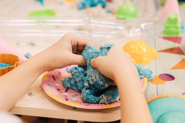 Foto kinetisch zand kinderhanden spelen met veelkleurig polymeerzand