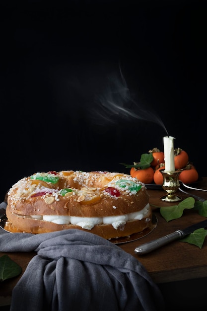 King cake with cream and fruit Typical Christmas sweet in Spain with dark background Cake for a ce