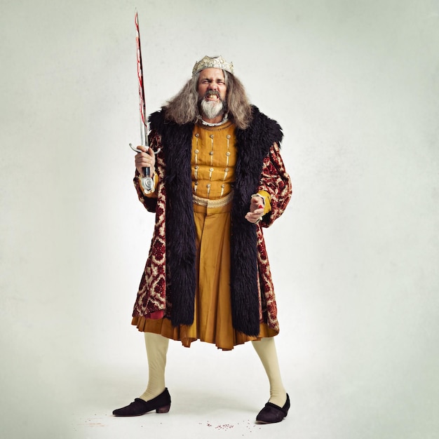 king portrait and man with bloody sword in studio isolated on a gray background mock up victorian villain medieval royal or mature male evil ruler or angry leader holding steel blade after battle