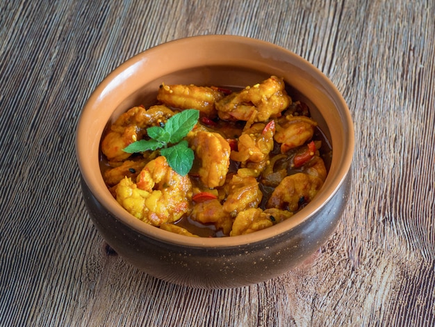 King prawn masala in a clay bowl. traditional indian cuisine