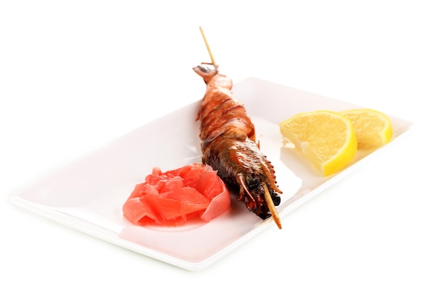 King prawn skewers on plate with ginger and lemon isolated on white