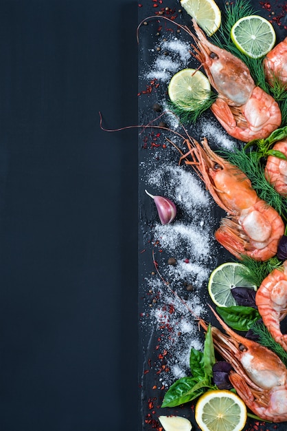 Photo king prawn with spices and herbs: salt, garlic, fennel, basil, lime, pepper, lemon.