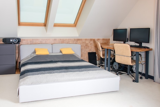 Foto kingsize bed met geel en grijs beddengoed in een moderne slaapkamer. stijlvol interieur met comfortabel bed en werkplek.