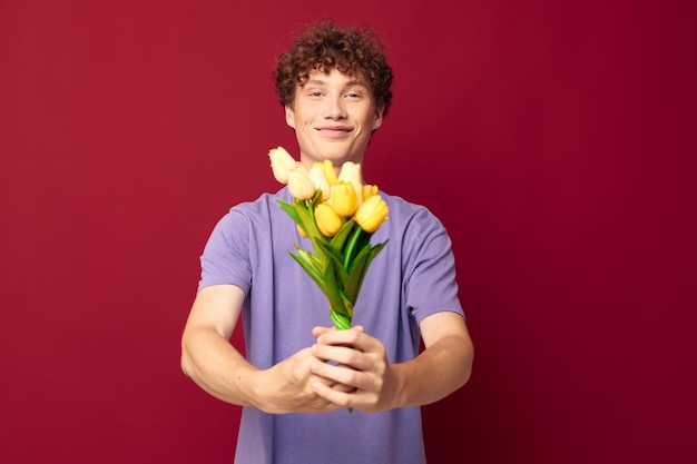 Kinky guy red hair in casual wear bouquet of flowers gift red background unaltered