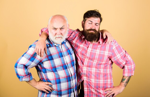 Kinship two bearded men senior and mature father and son family generational conflict barbershop and hairdresser salon male beard care checkered fashion youth vs old age compare retirement