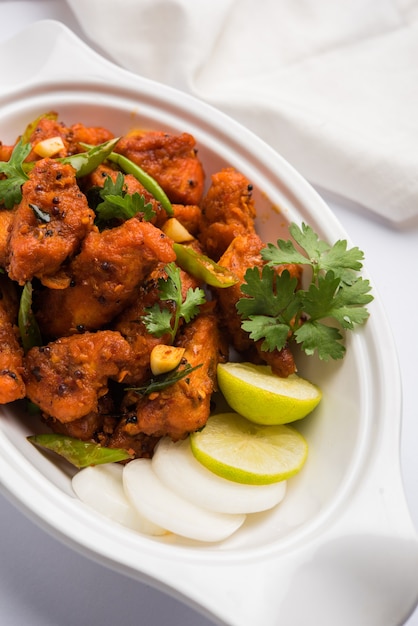 Foto kip 65 pittig gefrituurd bar-voorgerecht of snelle snack uit india in een kom of bord over wit