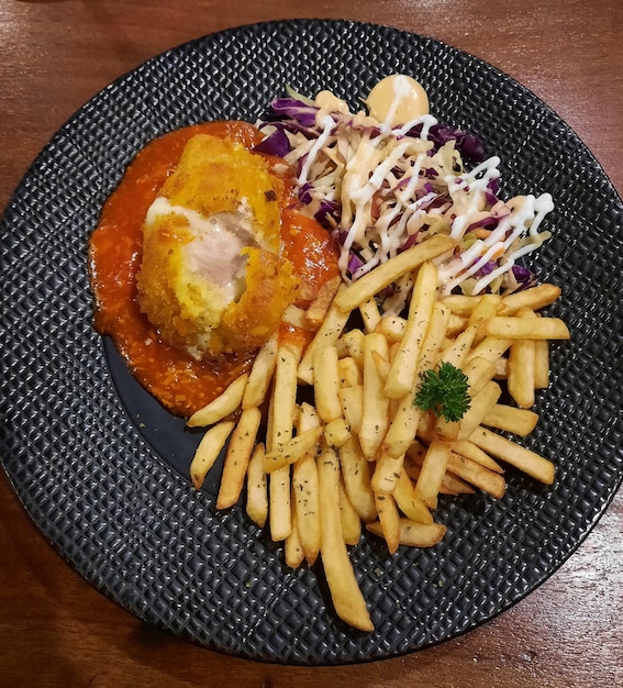 Foto kip cordon bleu met frites en salade ter plaatse