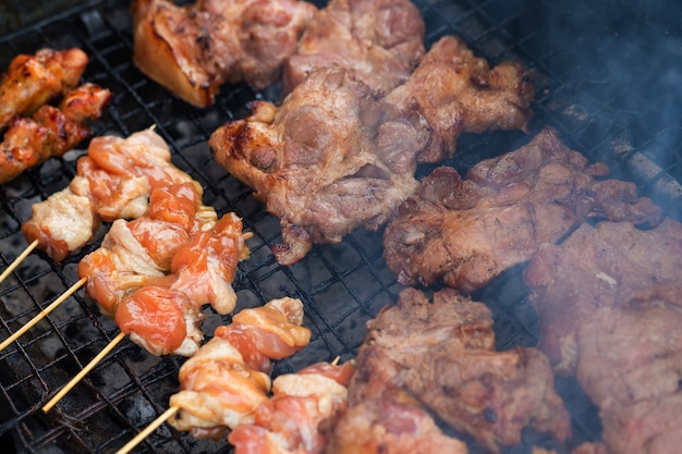 Kip en varkensvlees grill boven de kleine vlam