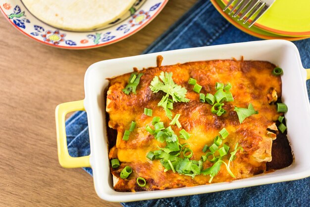 Kip enchiladas met cheddar kaas en saus.