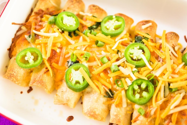 Kip enchiladas met cheddar kaas en saus.