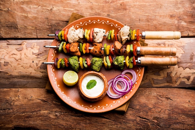 Kip Hariyali kakab of Malai malai kebab in driekleur geserveerd met spiesjes en yoghurtdip in een bord