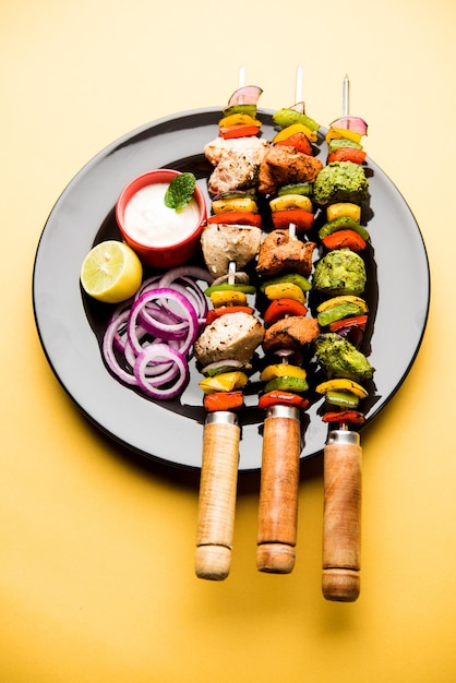 Kip Hariyali kakab of Malai malai kebab in driekleur geserveerd met spiesjes en yoghurtdip in een bord