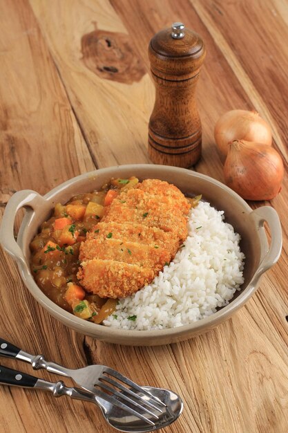 Kip Katsu Varkensvlees Tonkatsu met Japanse Curry Serveer met Witte Rijst op Bruine Keramische Plaat op Houten Tafel