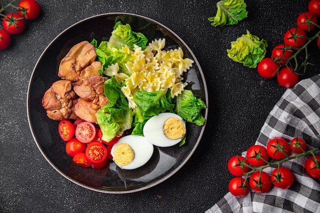 kip lever salade tomaten groene blad sla gekookt ei farfalle pasta pasta salade klaar om te eten