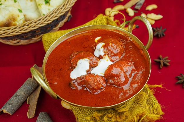 Kip makhani of kipboter masala korma rogan met brood geserveerd in karahi geïsoleerd op tafel