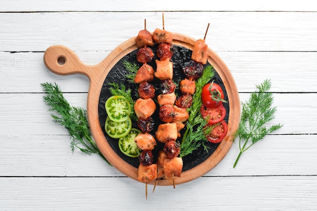 Kip shish kebab met kerstomaatjes op een witte houten achtergrond Vlees bovenaanzicht Gratis kopie ruimte