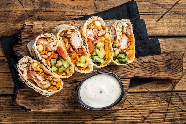 Kip wrap roll durum doner kebab met vlees en groentesalade Houten achtergrond Bovenaanzicht