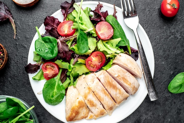 Kipfilet met salade en spinazie gezonde voeding op stenen tafel