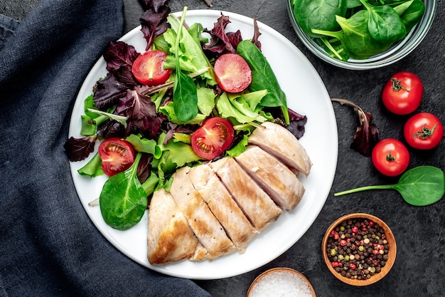 Kipfilet met salade en spinazie Gezonde voeding op stenen tafel