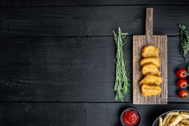 Kipfiletnuggets gebakken op zwarte houten tafel