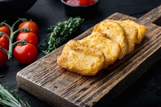 Kipfiletnuggets gebakken op zwarte houten tafel.