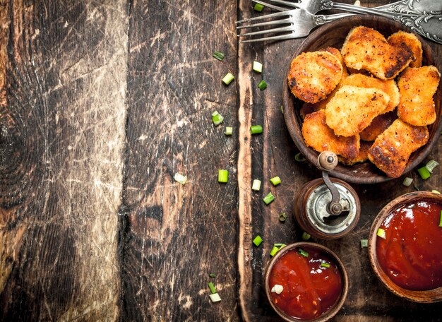 Kipnuggets in een kom met tomatensaus.