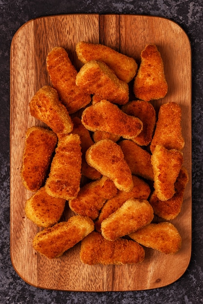 Kipnuggets op een houten bord