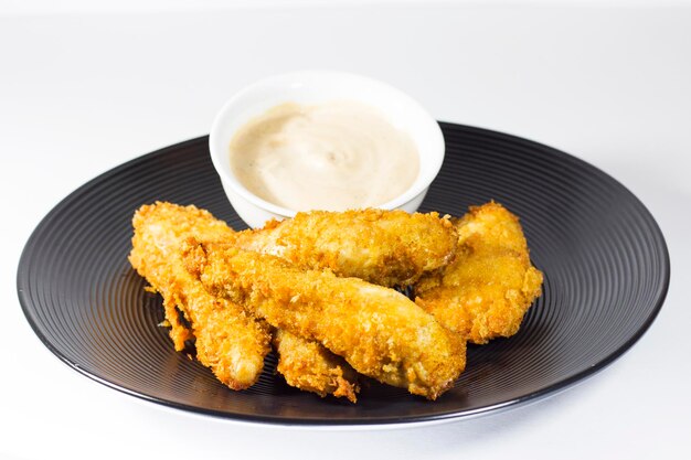 Foto kippen nuggets op het bord en souse witte achtergrond studio opname